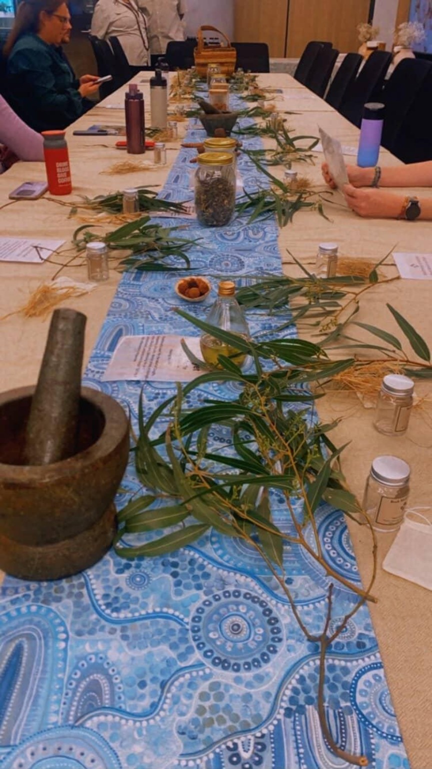 Bush plants, a grinding stone and workshop materials arranged on a table