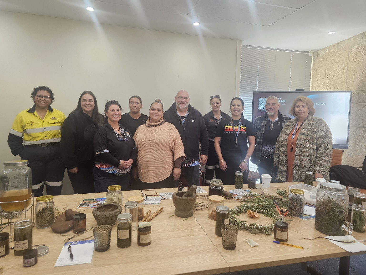 Workshop participants proudly standing behind their completed bush medicine products
