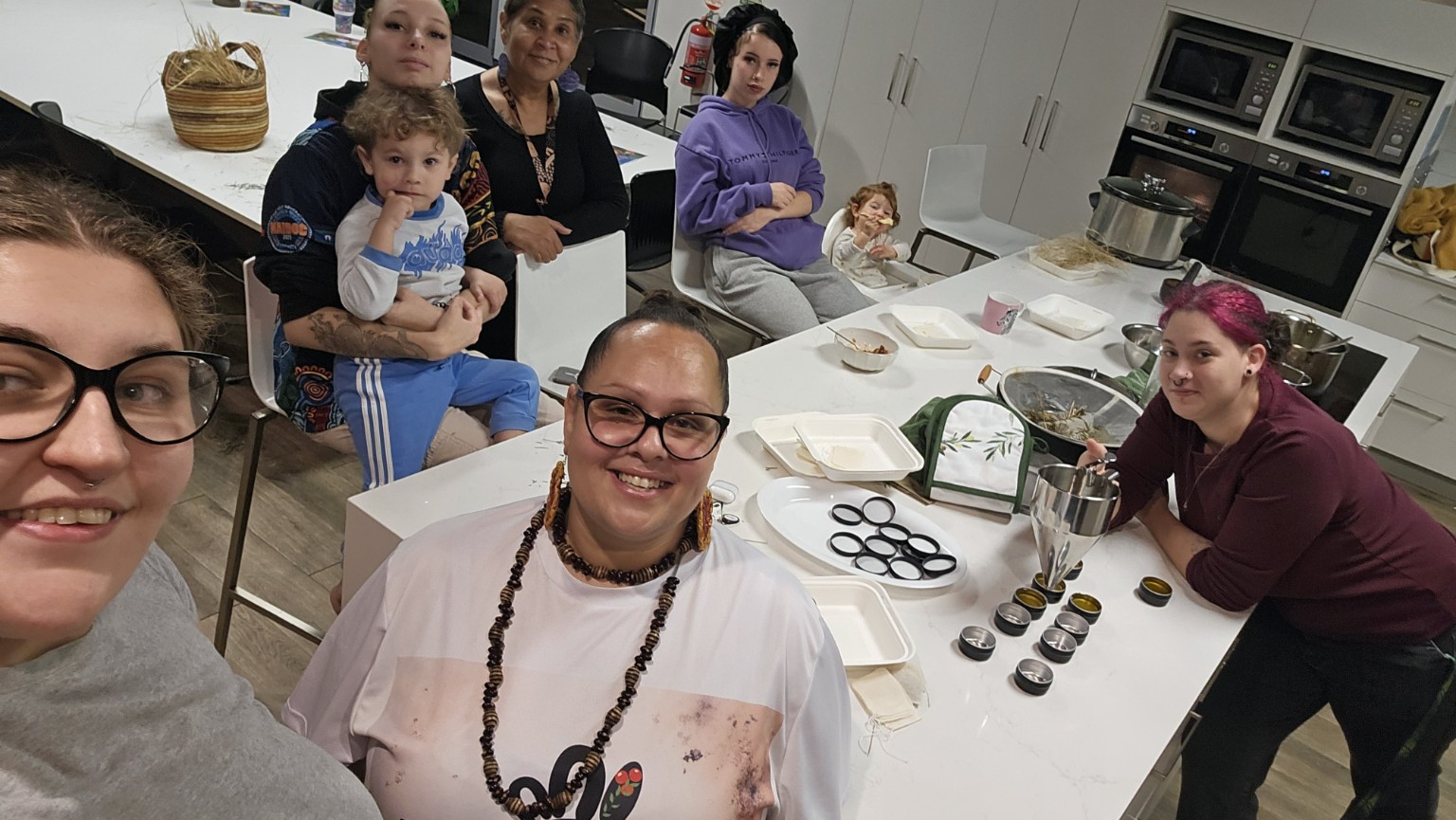 A relaxed group gathered around the bush medicine workshop table